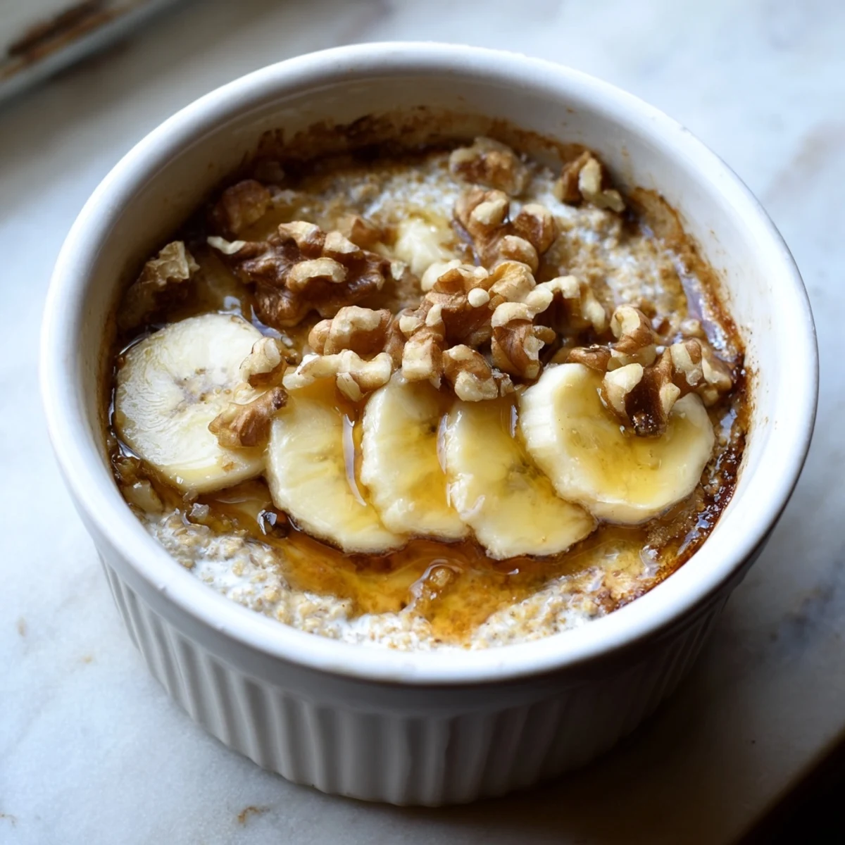 Golden-brown Baked Oats Ramekins with Banana, drizzled honey, promising a warm, delightful breakfast.