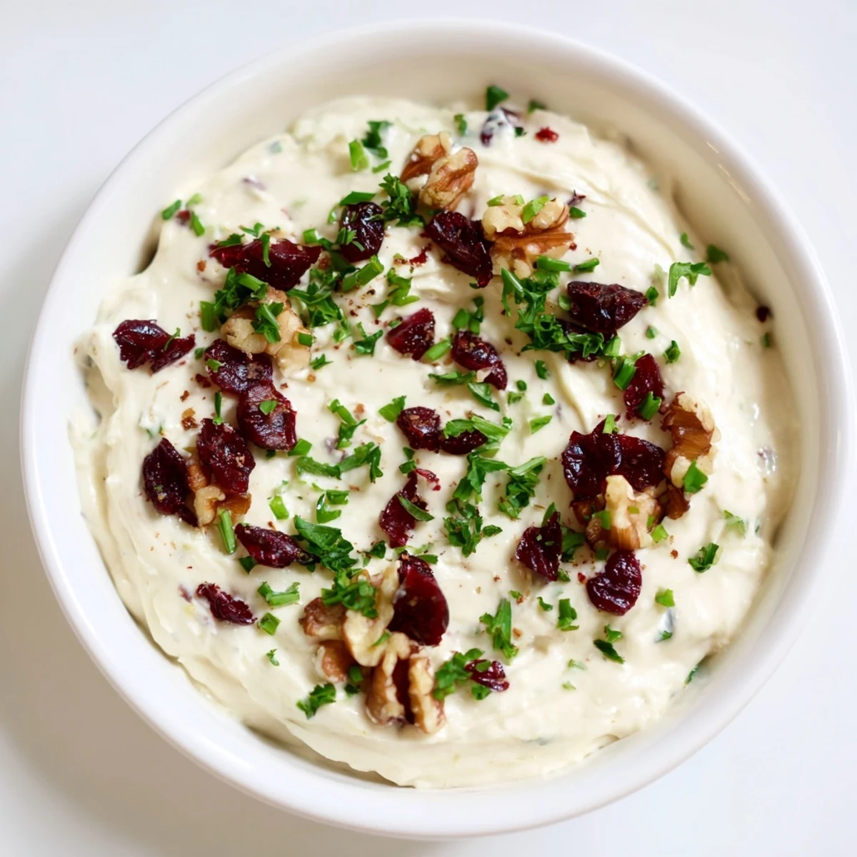 A close-up of the lightened holiday cream cheese dip, showing its smooth texture and walnut garnish.