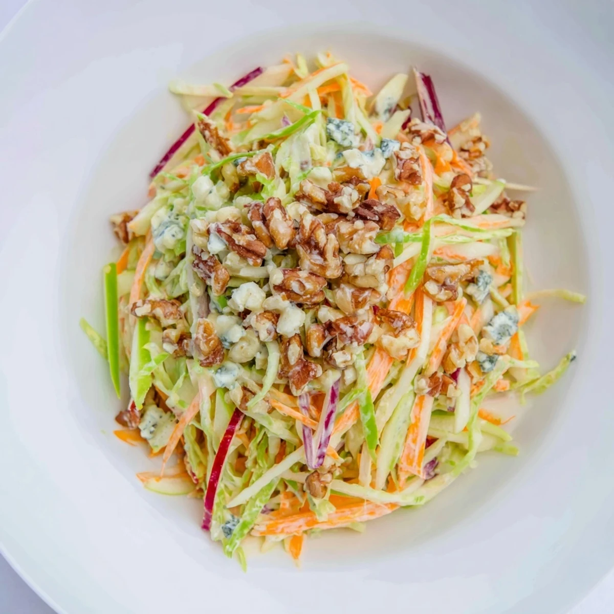 Fresh, crunchy Apple & Walnut Slaw with vibrant colors and creamy blue cheese crumbles.