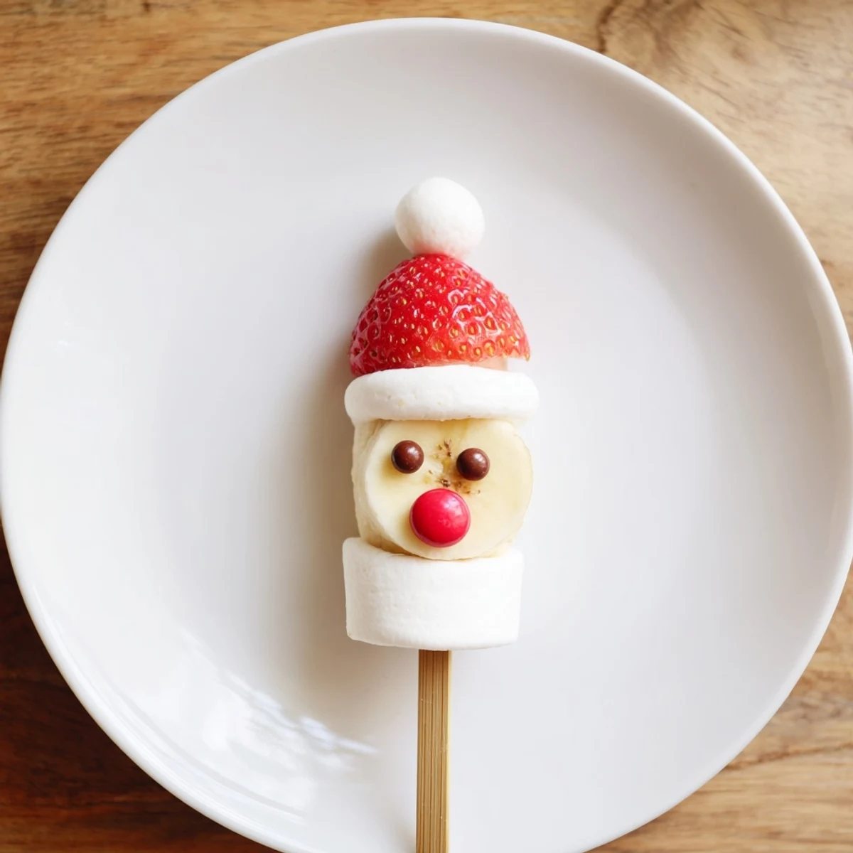 Banana Santa Snack Sticks on a skewer, with a red strawberry hat, ready to be enjoyed!