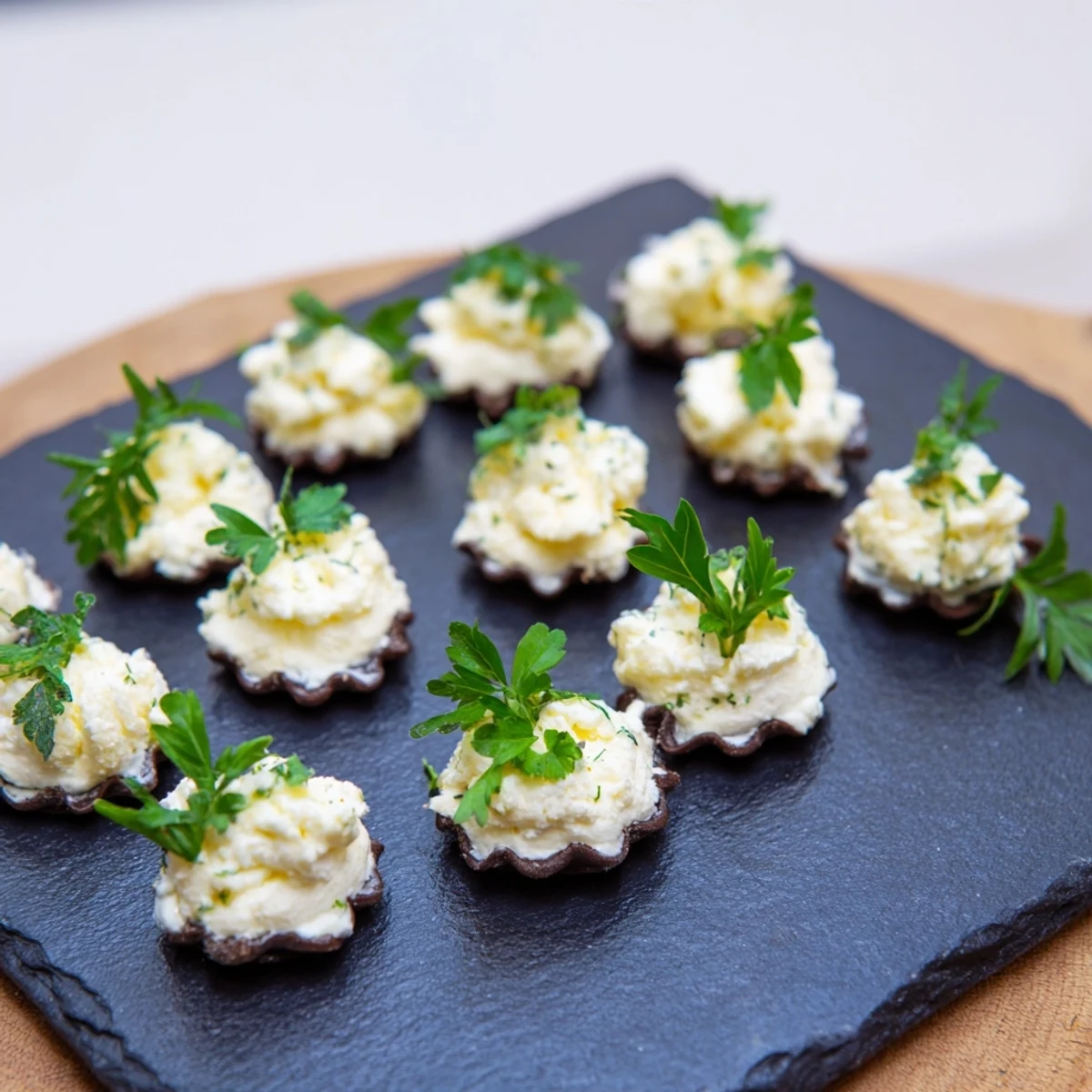 Crisp charcoal crackers topped with creamy goat cheese, this Stormy Sea appetizer looks delicious.