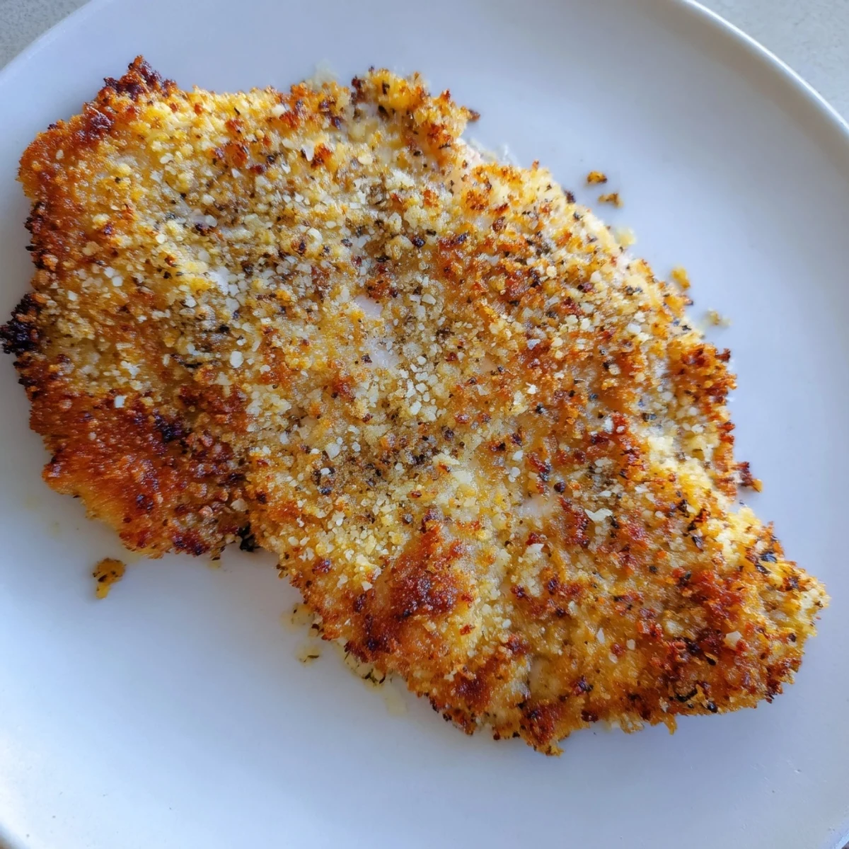 Close-up of juicy air fryer chicken cutlets, coated in golden-brown breading, a delicious main dish.