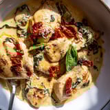 Spoonful of luscious Creamy Garlic Butter Tuscan Chicken glistens; serve hot over pasta.