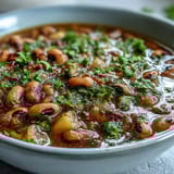Black-Eyed Pea Stew with Chefs Touch simmering in a pot, revealing a rich tomato broth and colorful veggies.