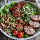 A close view of the Hoppin John Style Black-Eyed Pea Salad with Turkey Sausage reveals sautéed sausage slices, diced peppers, and fresh tarragon tossed in a zesty honey-mustard vinaigrette.  