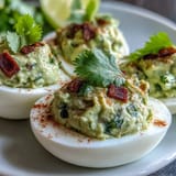 Vibrant avocado and lime filling transforms deviled eggs into a fresh, zesty appetizer.  