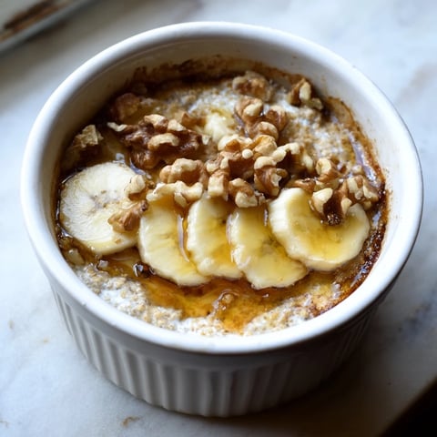 Golden-brown Baked Oats Ramekins with Banana, drizzled honey, promising a warm, delightful breakfast.