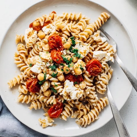 Golden-brown Baked Feta Chickpeas & Tomatoes swimming in a rich sauce, ready to be served over pasta.