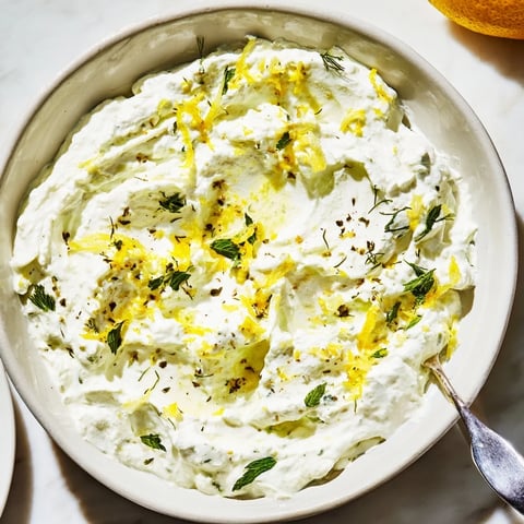 Creamy whipped feta dip, vibrantly garnished, perfect for dipping warm pita bread.