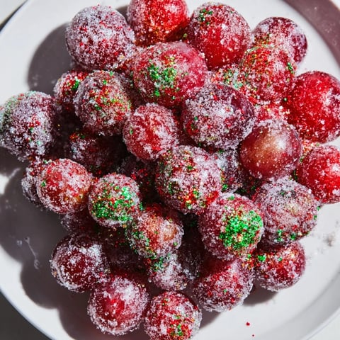 Frozen grape treats displayed on a baking sheet, glistening with sugar, ready for a party.
