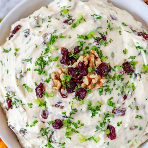 Creamy, lightened holiday cream cheese dip with vibrant cranberry flecks and fresh herbs for dipping.