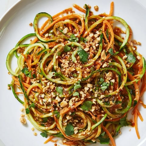 Spicy cucumber noodle bowl, a vibrant mix of spiralized cucumbers and zesty chili sauce in a bowl.