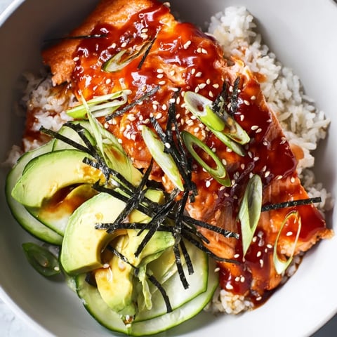 Emily Mariko's Sticky Orange Gochujang Salmon Bowl; tender salmon glazed, served over rice with fresh veggies.