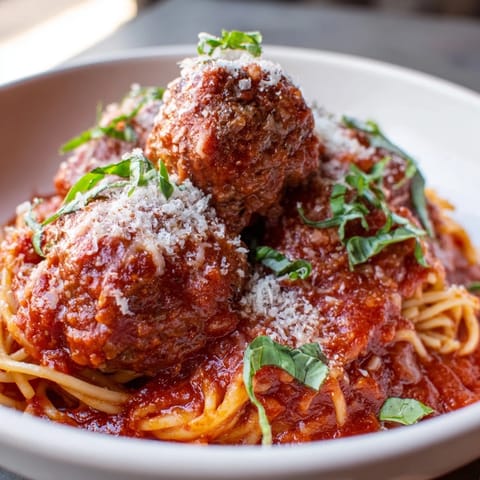 Crispy meatballs nestled in hearty tomato sauce served over spaghetti noodles.  