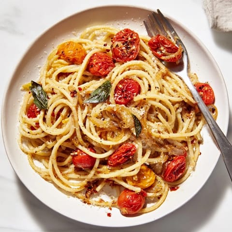 Tender spaghetti in a skillet with vibrant Lazy-Girl Pasta sauce, ready for a simple dinner.