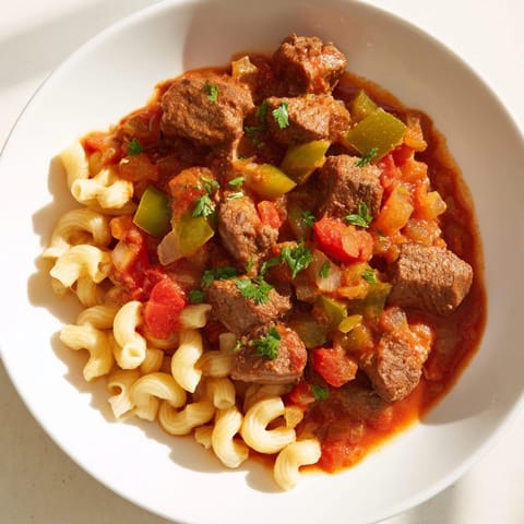 Close-up of a flavorful goulash, showcasing tender beef and pasta in a rich tomato sauce.