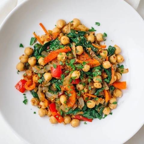 Golden, steaming Vegetarian Chickpea & Spinach Skillet, garnished with fresh herbs, ready to serve.