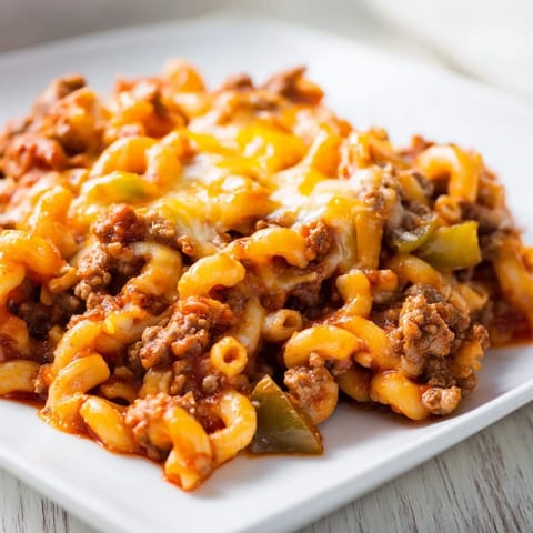 A flavorful close-up shows steaming Hamburger Casserole, showcasing the tender pasta and savory beef.