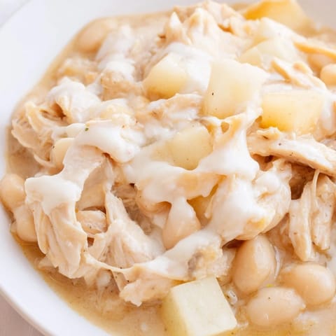 Steaming bowl of 35-minute white cheddar apple chicken chili with melted cheese and apple pieces.