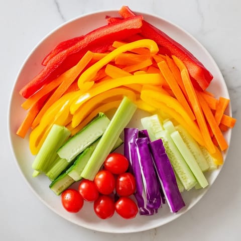 Vibrant Rainbow Arch Bright Veggie Sticks, a rainbow of crisp peppers, carrots, and tomatoes ready to dip.