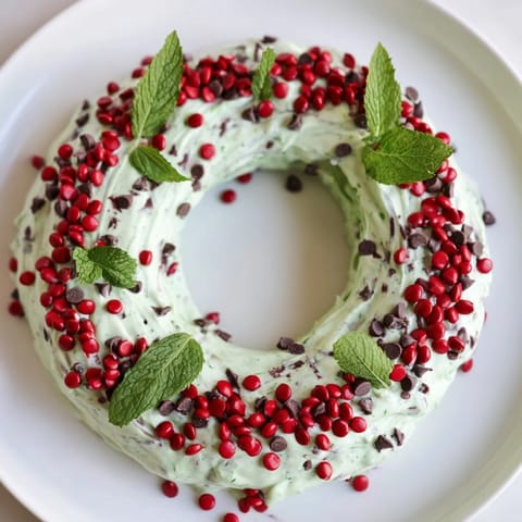 A close-up of a festive Mint Chocolate Chip Dip Wreath, ready to be scooped with cookies.