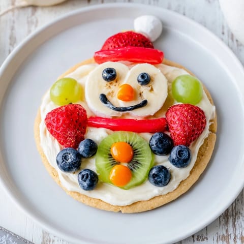 Enjoy this sweet Melting Snowman Fruit Pizza featuring a delightful sugar cookie crust and fresh fruit.