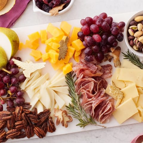 Festive Twelve Days of Christmas Snack Board overflowing with colorful cheeses, fruits, and treats for guests.
