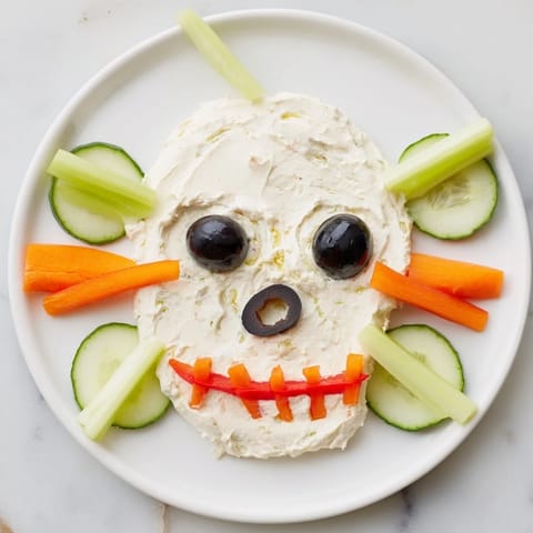 Close-up of the Skull & Bones Spooky Spread: a spooky, creamy appetizer with vibrant vegetable details.
