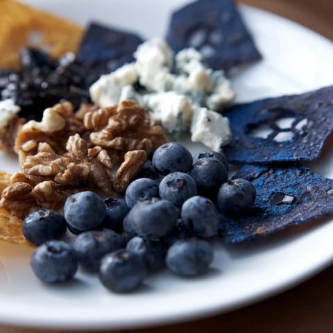 A close-up of The Olympic Rings appetizer, showcasing colorful tomatoes and sweet pineapple chunks.