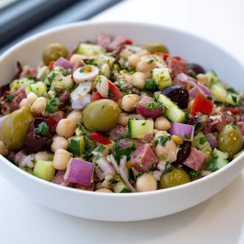 A close-up of Mediterranean Dense Bean Salad with salami showcasing fresh ingredients and flavors.