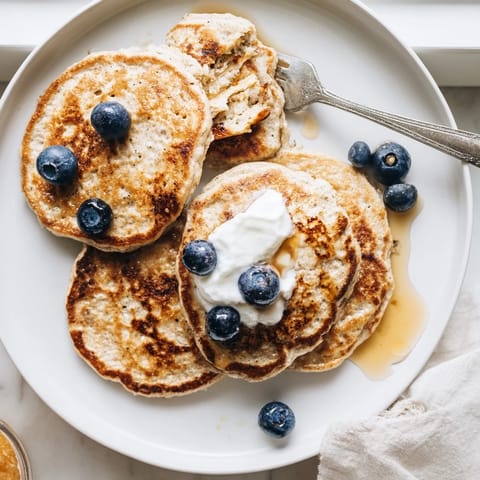 Golden-brown Cottage Cheese Pancakes cooking on a griddle, bubbling as they become perfectly crisp.  
