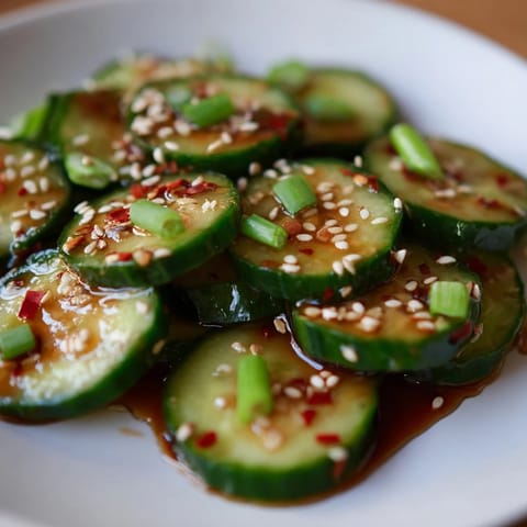Crisp cucumber slices tossed in a savory garlic and sesame dressing inside a mason jar for this easy Shake Shake Garlic Cucumbers recipe.