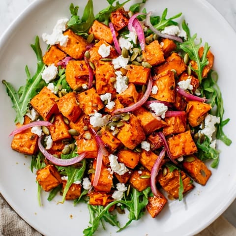 This vibrant Roasted Sweet Potato Salad features golden roasted sweet potatoes and crumbled feta cheese on fresh arugula.  