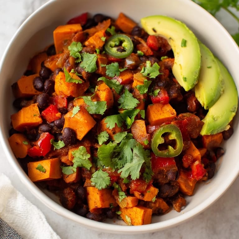 Close-up of a bubbling pot of flavorful Sweet Potato & Black Bean Chili, perfect for chilly evenings.