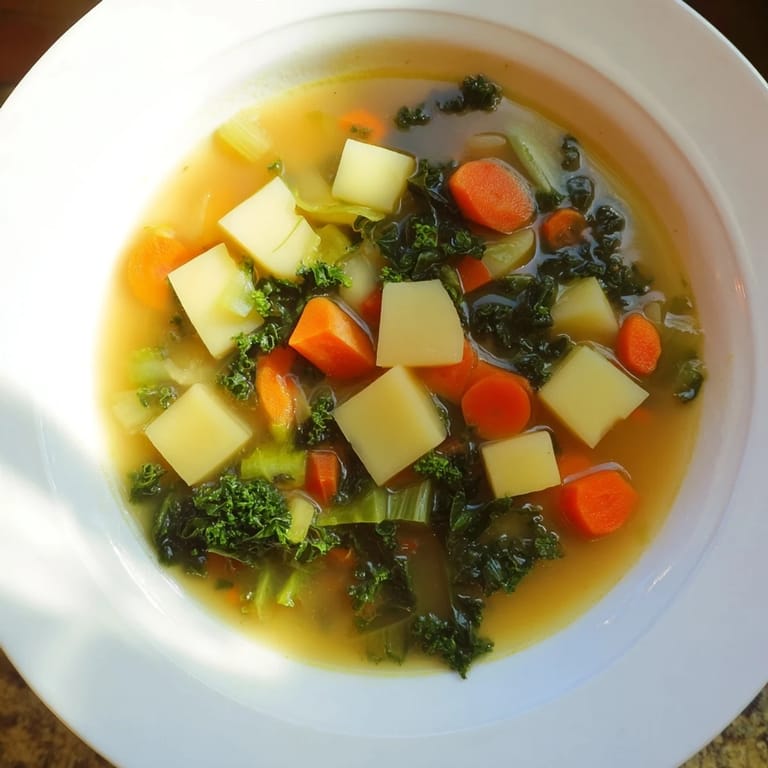 Delicious, homemade Vegetarian Potato-Kale Soup, perfectly simmered and ready to serve with crusty bread.
