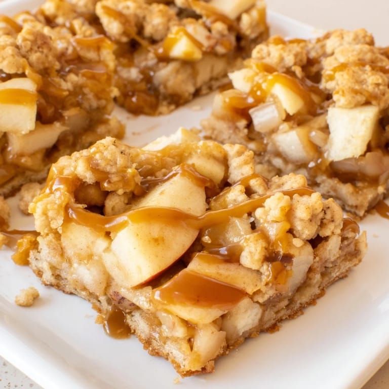 These warm Caramel Apple Cookie Bars showcase golden, crumbly topping and a sweet, baked apple interior.