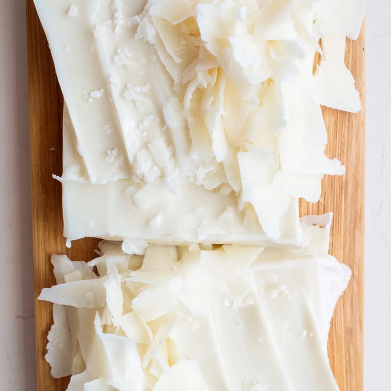 Crisp, elegant presentation of The Arctic Tundra dessert: white chocolate "icebergs" alongside savory Parmesan.