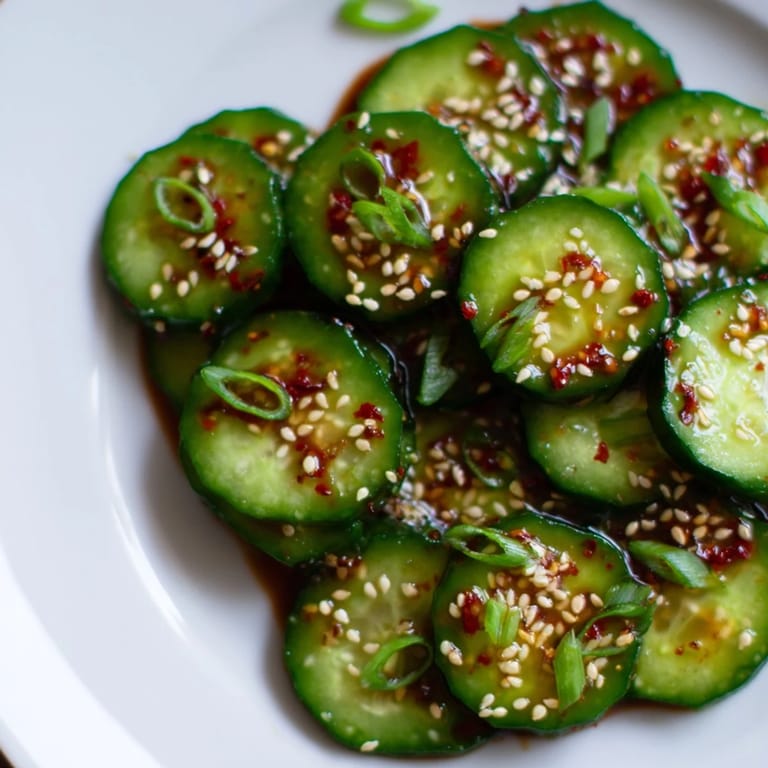 Vibrant Asian-inspired Shake Shake Garlic Cucumbers served chilled in a white bowl, ideal as a refreshing vegan appetizer or light snack.