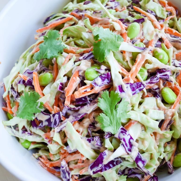 Close-up of the Crunchy Thai Peanut Salad showing crunchy vegetables, edamame, and peanuts, with tangy dressing drizzled for a colorful, healthy side dish.