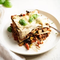 Golden baked One-Pan Smoky Veggie Lentil Lasagne ready to serve with basil.