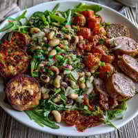 Topped on fresh greens, this Hoppin John Style Black-Eyed Pea Salad with Turkey Sausage showcases colorful vegetables and a light mustard-tarragon dressing for a vibrant Southern meal.  