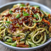Healthy Easy Zucchini Noodle Stir-Fry with Peanut Sauce, featuring vibrant spiralized zucchini tossed in a creamy, tangy peanut sauce.